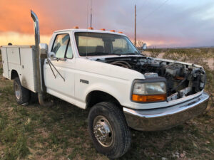 White 1995 Ford F-Superduty chassis cab with a service body and no hood, an entrant in the 2020 Virtual Truck Show.