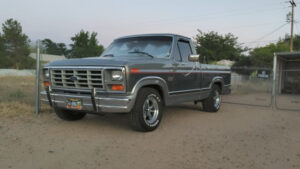 A light blue 1986 Ford F150 XL short wide bed with aluminum wheels and a lowered stance, featured in the 2020 Virtual Truck Show.