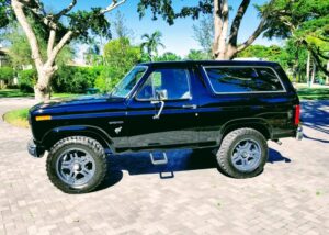 A restored white 1985 Ford Bronco XLT with 35-inch tires and custom dual exhaust, featured in the 2020 Virtual Truck Show.