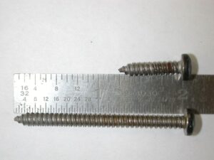 A comparison photo showing a short N610019-S pan-head screw and a longer N610025 pan-head screw used for Ford truck headlight doors.