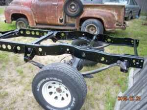 Photos of an original 1981 Ford F-150 4WD frame with factory-cut lightening holes, shown during a restoration process.