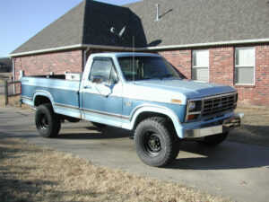 A functional, high-mileage 1985 Ford F-250HD 4x4 work truck with a flatbed and 460 V8.