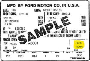 A sample Ford Motor Co. manufacturing label from 1/85 showing GVWR and GAWR ratings, with a specific highlighted box in the bottom right containing the codes F0113 and T0492.