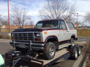 Tan and white 1985 Ford Bronco XLT on a trailer, featuring a built 351W engine, an entrant in the 2020 Virtual Truck Show.