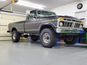 Black and silver two-tone 1977 Ford F250 Highboy with large West Coast mirrors, an entrant in the 2020 Virtual Truck Show.