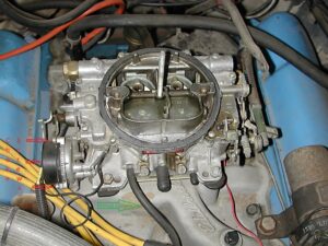 A top-down reference photo of an Edelbrock 1406 carburetor showing the choke adjustment screws and the ported vacuum port.