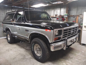 Two-tone silver and black 1982 Ford Bronco XLT with custom painted stripes and factory chrome wheels, an entrant in the 2020 Virtual Truck Show.