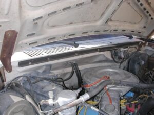 Close-up of a DIY cowl seal installation on a Ford Bullnose truck using garage door seal and black neoprene adhesive.