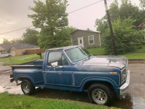 A blue 1981 Ford F150 Flareside with natural patina parked in a driveway, alongside a close-up of its custom aftermarket gauge cluster.