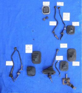A collection of Ford truck manual transmission shift levers and boots, showing the differences between the 1980–82 NP435 levers and the 1983–87 T-18/T-19 versions.